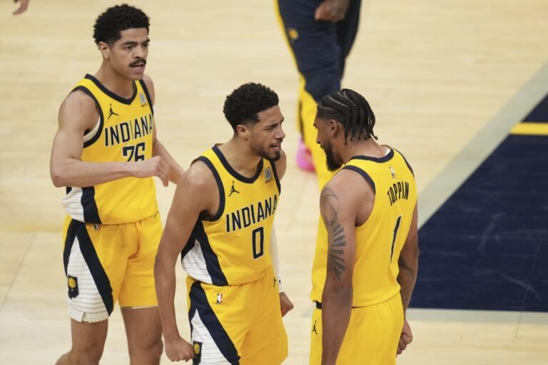 Indiana Pacers guard Ben Sheppard (26), guard Tyrese Haliburton (0) and forward Obi Toppin (1) celebrate during the first half of Game 3 of the Eastern Conference finals of the NBA basketball playoffs against the New York Knicks Sunday, May 25, 2025, in Indianapolis. (AP Photo/Jeff Roberson)